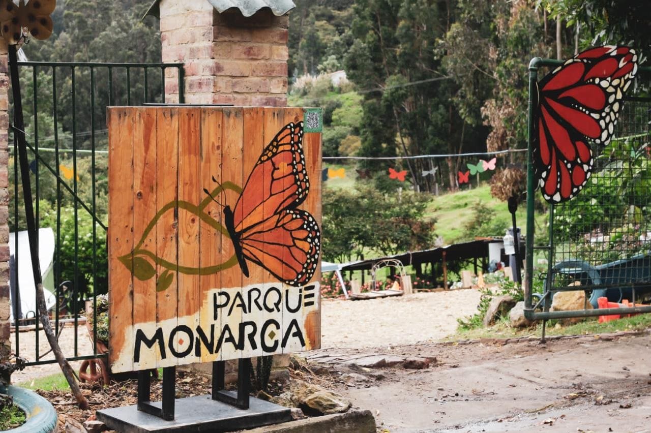 Letrero original de madera de Parque Monarca con una mariposa monarca